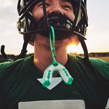 boy with football gear and mouthguard