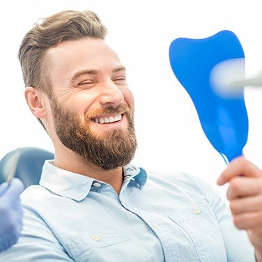 man smiling in blue mirror