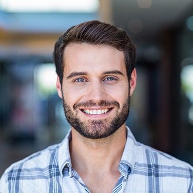 Man in patterned shirt smiling after cosmetic dentistry in Wilton Manors, FL