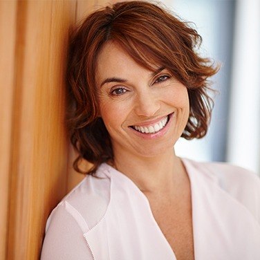 woman smiling against wall