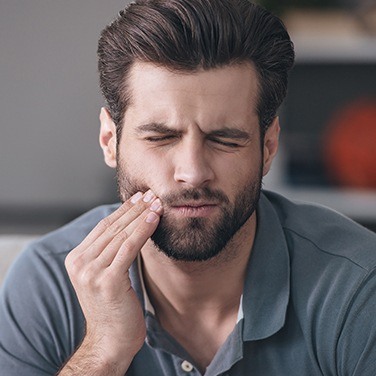 man holding jaw in pain