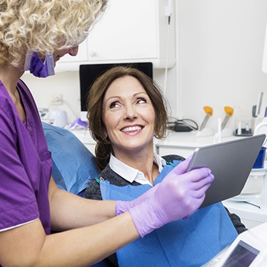 dentist showing a patient information on a tablet 