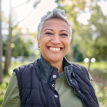 Senior woman in jacket outside and smiling