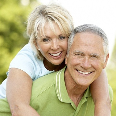 man giving woman piggy back ride