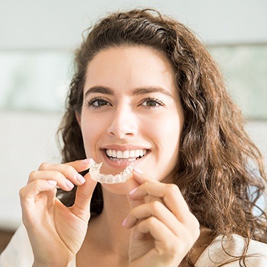 woman holding invisalign