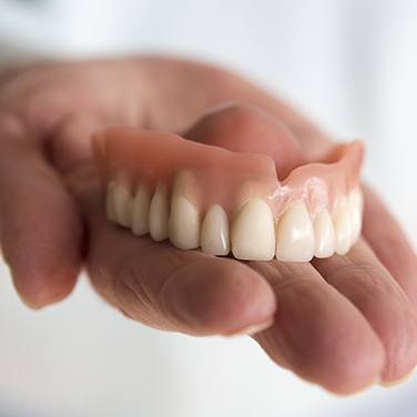 top dentures in hand