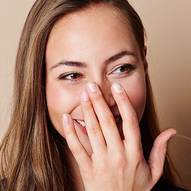 woman covering smile