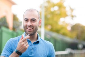 man smiling holding invisalign