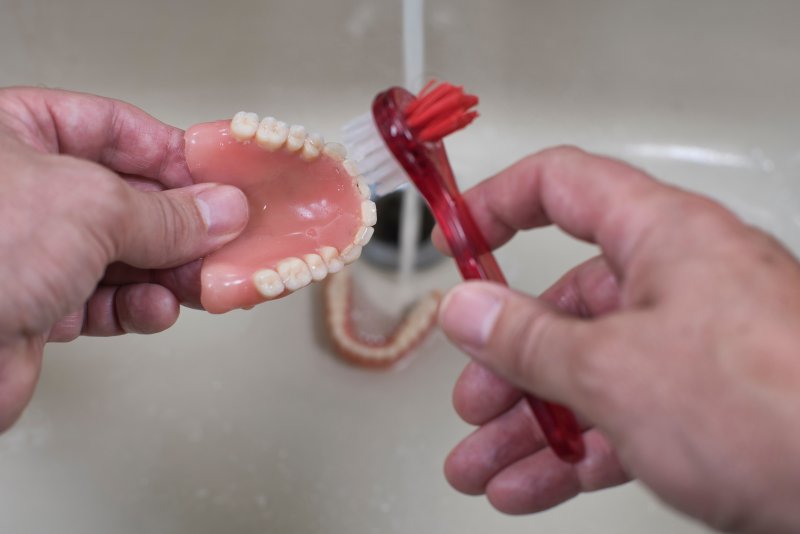 person caring for dentures