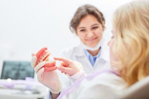 Dentist and patient checking out dentures.